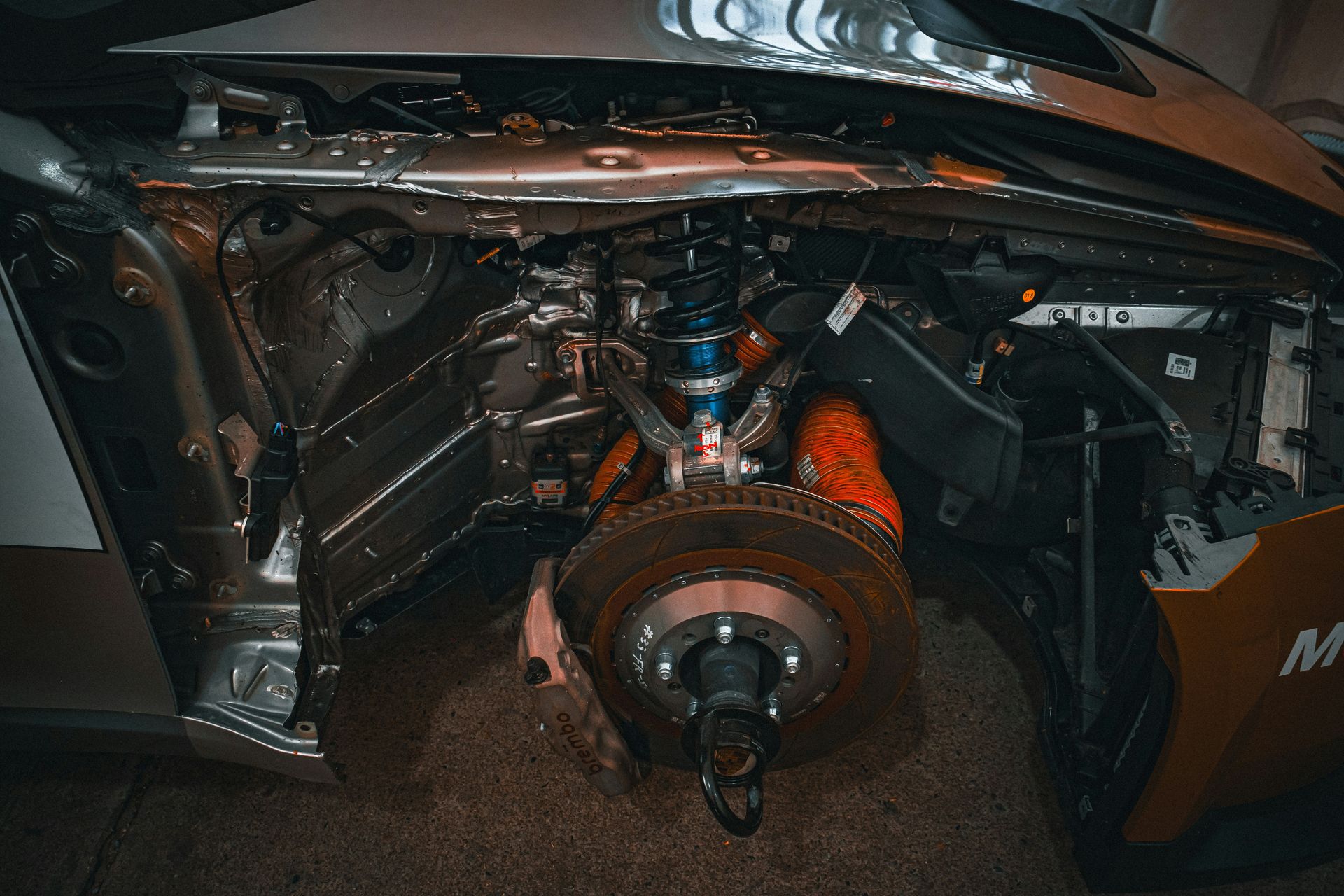 Exposed car front suspension and brake assembly.